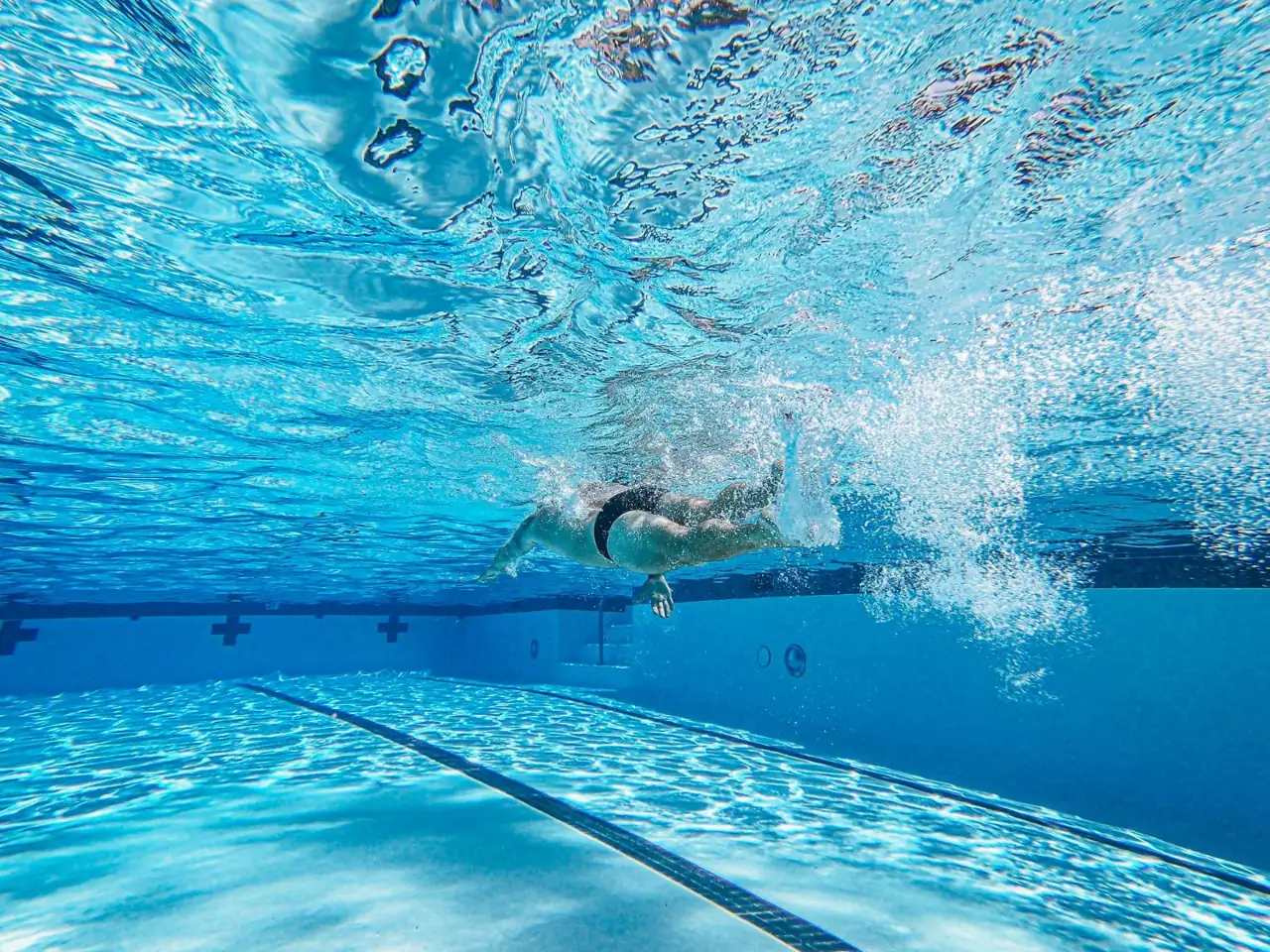 A swimmer seen from underwater in a pool